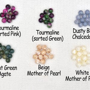 May include: An assortment of gemstone beads in various colors, including pink and green tourmaline, dusty blue chalcedony, light green agate, and beige and white mother of pearl. Text labels identify each type of bead.