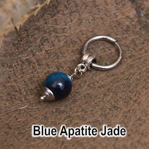 May include: A single silver hoop earring with a dangling blue apatite jade bead. The bead is a deep blue color with a silver cap. The text "Blue Apatite Jade" is displayed at the bottom of the image.