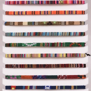 Peut inclure: Une vari&eacute;t&eacute; de cordons tiss&eacute;s color&eacute;s, pr&eacute;sent&eacute;s sur une carte blanche, chaque cordon pr&eacute;sentant un motif unique.