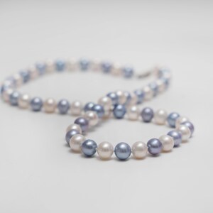 May include: A pearl necklace with alternating white and blue pearls.