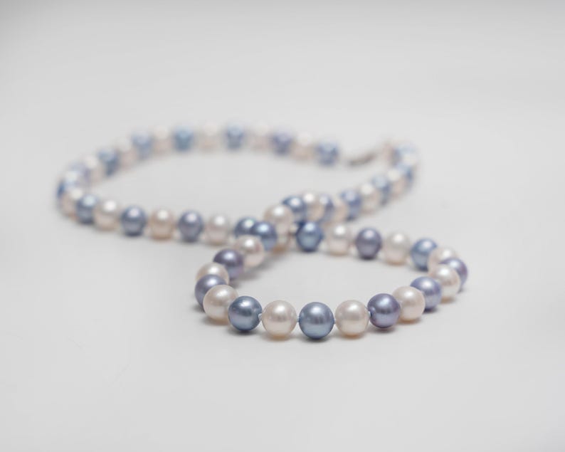 May include: A pearl necklace with alternating white and blue pearls.