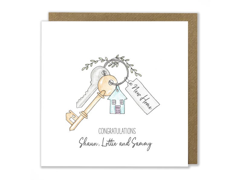 Puede incluir: Una ilustraci&oacute;n de acuarela de una llave de casa con una etiqueta que dice "Nuevo hogar" y un peque&ntilde;o amuleto de casa. La tarjeta dice "Felicidades Shaun, Lottie y Sammy".