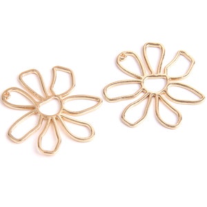 Könnte beinhalten: Zwei goldfarbene Metall-Anhänger in Form einer Daisy mit einem Loch oben zum Anbringen an Schmuck oder anderen Bastelarbeiten.