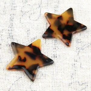May include: Two brown and black tortoiseshell star-shaped resin pendants.