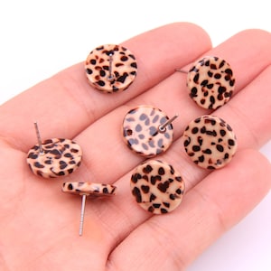 Puede incluir: Seis pares de pendientes de botón redondos de estampado de leopardo marrón y crema con postes plateados.