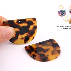 Puede incluir: Dos piezas de resina en forma de semicírculo de color marrón y negro con aspecto de caparazón de tortuga, con un agujero en la parte superior. La parte metálica no está incluida. (Solo para la foto)