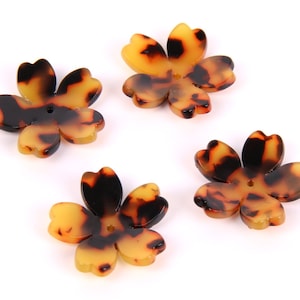 Peut inclure: Quatre boutons en plastique en forme de fleur, de couleur marron et jaune, avec un trou au centre.