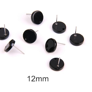 Puede incluir: Siete pares de pendientes redondos negros con postes plateados. Los pendientes tienen un diámetro de 12 mm.