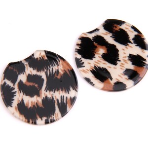 May include: Two round, brown, black and white leopard print earrings.
