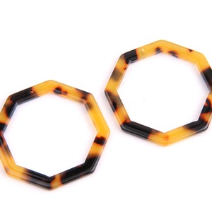 May include: Two octagonal shaped earrings made of brown and yellow tortoiseshell plastic.