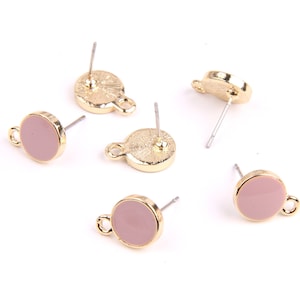 May include: Five pairs of gold-tone stud earrings with pink round cabochon stones. The earrings have a simple design and are perfect for everyday wear.