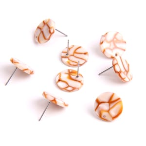 Puede incluir: Ocho pares de pendientes redondos con estampado blanco y marrón con postes plateados.