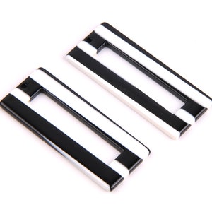 May include: Two black and white striped rectangular plastic charms with a hole at the top.