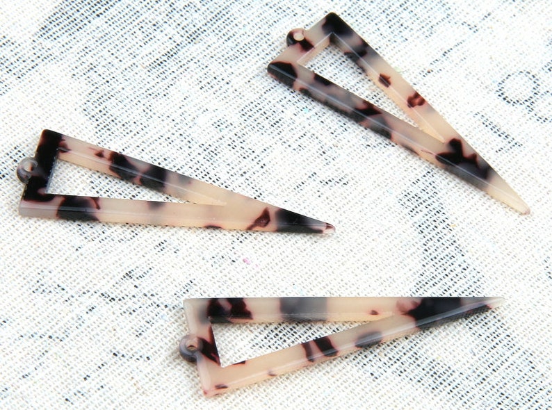 Puede incluir: Tres pinzas para el pelo en forma de tri&aacute;ngulo de caparaz&oacute;n de tortuga. Las pinzas son de color marr&oacute;n claro con vetas negras y blancas.