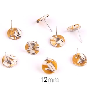 Puede incluir: Siete pares de pendientes de botón redondos, de 12 mm, marmoleados en marrón y blanco con postes plateados.