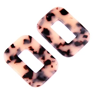 Può includere: Due orecchini rettangolari con motivo a tartaruga con un foro nella parte superiore per appenderli.