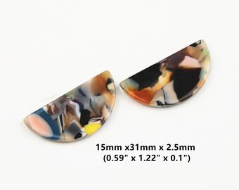 Könnte beinhalten: Zwei bunte, halbkreisförmige Acrylharzformen mit Marmormuster. Die Formen sind etwa 31 mm lang, 15 mm breit und 2,5 mm dick.
