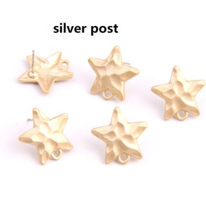 May include: Five gold-toned star-shaped earring charms with a textured surface. Each charm has a small loop at the bottom and a silver post on the back.