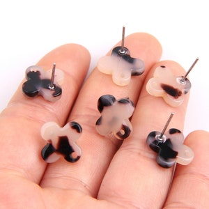 May include: Five pairs of black and white patterned butterfly shaped earrings with silver posts.