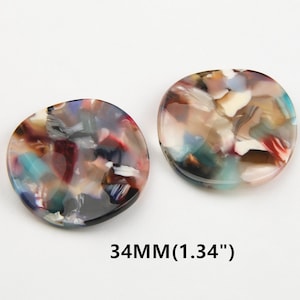 May include: Two round, colorful, abstract patterned resin buttons, each measuring 1.34 inches in diameter.  34MM (1.34")