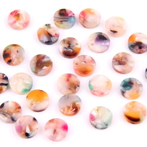 May include: Assortment of colourful round resin buttons with marbled patterns. The buttons are approximately 1 inch in diameter and have a glossy finish.