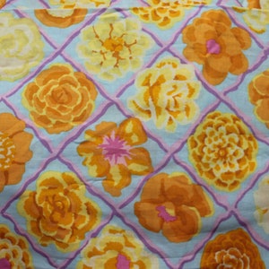 May include: A blue and purple fabric with a repeating pattern of yellow, orange, and pink flowers. The flowers are stylized and have a vintage look.