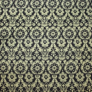 May include: A black and gold patterned fabric with a repeating design of stylized flowers and leaves.