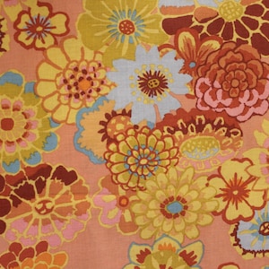 May include: A colorful floral fabric with a retro design featuring a variety of flowers in shades of orange, yellow, pink, and blue on a peach background.