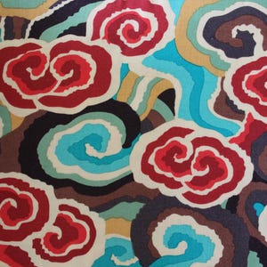 May include: A colorful fabric with a repeating pattern of stylized red, white, and blue cloud-like shapes. The design also incorporates swirls of teal, brown, and yellow, creating a vibrant and dynamic textile.
