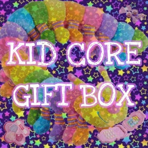 May include: A colorful Kid Core Gift Box with a plush caterpillar, a pink flip phone, and a flower-shaped makeup compact. The background is a purple fabric with star patterns. The text "KID CORE GIFT BOX" is displayed in white.