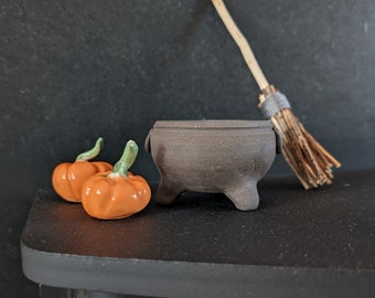 Teeny tiny cauldrons with pumpkins. ceramic.