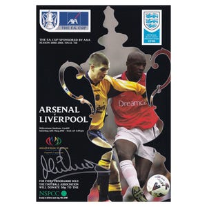 May include: A commemorative matchday program for the FA Cup Final 2000-2001 between Arsenal and Liverpool. The program features images of players in action, the logos of sponsors, and the official match details. The program is signed.