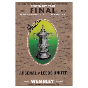 May include: A vintage souvenir programme for the 1972 Football Association Challenge Cup Final, Arsenal versus Leeds United at Wembley Stadium. The program features a silver trophy on a brown background, with the date, time, and team names.