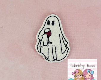 May include: White ghost with a red wine glass in its hand. The ghost is embroidered with glitter. The image has the text "Embroidery Fairies" at the bottom.