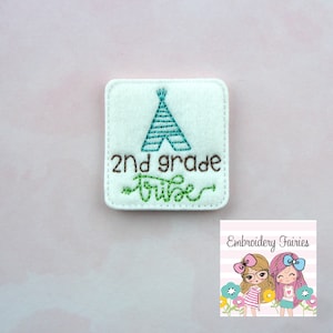 Puede incluir: Parche de fieltro blanco con bordado marrón que dice "2nd grade tribe" y un tipi bordado en verde y azul.
