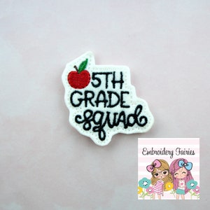 Puede incluir: Parche de fieltro blanco con bordado negro que dice "5th Grade Squad" con un gráfico de manzana roja.