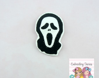 May include: Black and white embroidered iron-on patch of a ghost face mask with a wide open mouth.