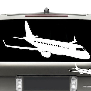 May include: A white silhouette of an airplane is displayed on the back window of a gray SUV. The airplane is facing to the right and is positioned in the upper portion of the window. A smaller silhouette of the same airplane is displayed below the larger one.