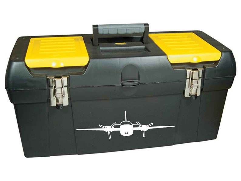 以下が含まれることがあります： 前面に白い飛行機のステッカーが付いた黒と黄色のツールボックス。ツールボックスにはハンドルと2つのラッチが付いています。