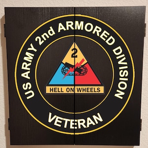 May include: A black rectangular cabinet with two hinged doors featuring the US Army 2nd Armored Division emblem. The circular logo includes a yellow border, the text US ARMY 2ND ARMORED DIVISION VETERAN, and a central triangle with a tank and HELL ON WHEELS.
