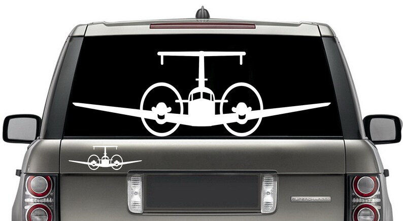 以下が含まれることがあります： 車の窓に貼るように設計された、プロペラ付きの双発機の白いビニールステッカーです。