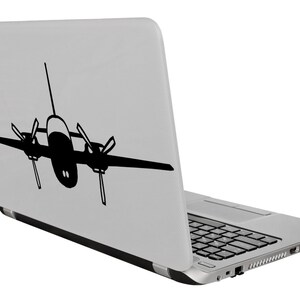 以下が含まれることがあります： 背面に黒い飛行機のシルエットのステッカーが貼られた銀色のラップトップ