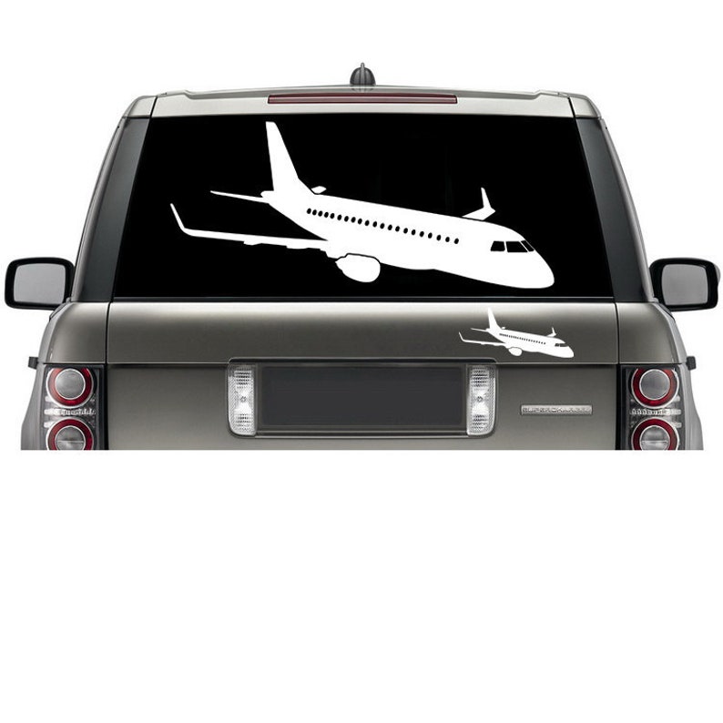 May include: A white silhouette of an airplane is displayed on the back window of a gray SUV. The airplane is facing to the right and is positioned in the upper portion of the window. A smaller silhouette of the same airplane is displayed below the larger one.