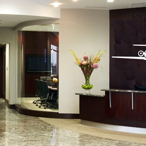 May include: A modern office lobby with a reception desk, a glass-walled conference room, and a large white airplane silhouette on the wall.