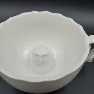 Puede incluir: Taza de té de cerámica blanca con un diseño de búho 3D en el interior. El búho es blanco y tiene un diseño detallado.