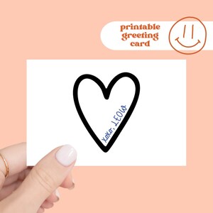 Peut inclure: Une carte de vœux blanche avec un contour de cœur noir et le texte bleu "xoxo, LEOW". La carte est tenue par une main avec une bague dorée, sur un fond pêche. La carte porte également le texte "carte de vœux imprimable".
