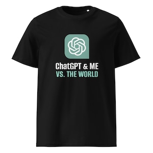 May include: Black t-shirt featuring the text "ChatGPT & ME VS. THE WORLD" in white and light blue. The shirt has a graphic of a white and light blue design inside a teal square. The shirt is a crew neck.