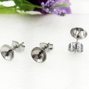 Puede incluir: Tres postes de pendientes de plata con una parte posterior redonda y plana. Los postes están diseñados para sujetar un dije u otra joya.