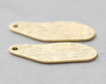May include: Two gold-coloured metal tags with a rounded rectangular shape and a small hole at the top.