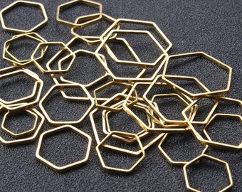 Könnte beinhalten: Ein Haufen goldfarbener sechseckiger Metallringe. Die Ringe sind alle gleich groß und gleich geformt und in einem zufälligen Muster angeordnet.